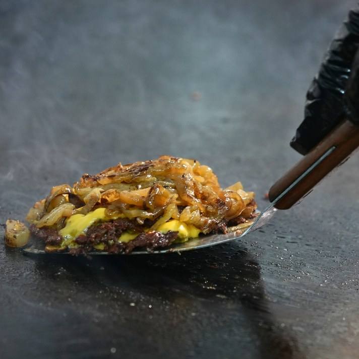 Smash patty with onions lifted off the griddle