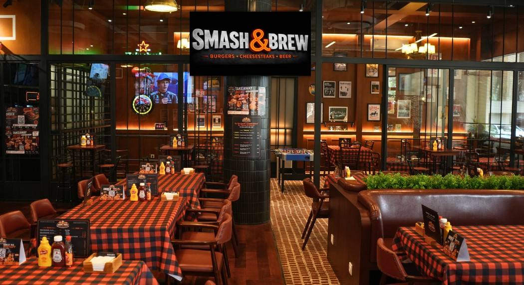 The dining floor — checkered tables, booths, and the game on